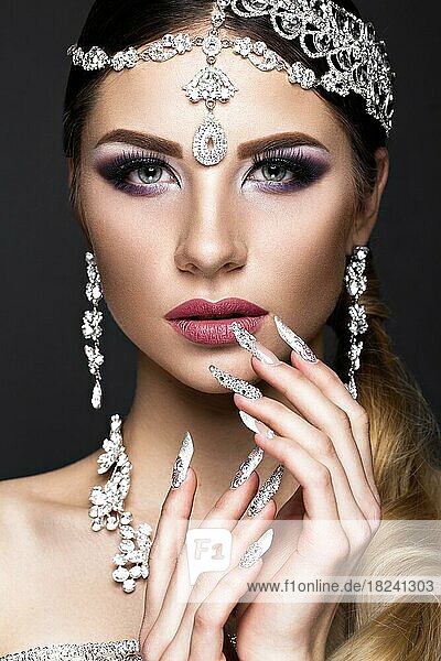 Beautiful girl in the image of the Arab bride with expensive jewelry  oriental make-up and bridal manicure. The beauty of the face. Photos shot in the studio