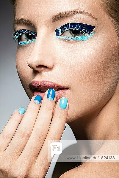 Schönes Mädchen mit hellen kreativen Mode Make-up und blauen Nagellack. Kunst Schönheit Nageldesign. Bild im Studio aufgenommen