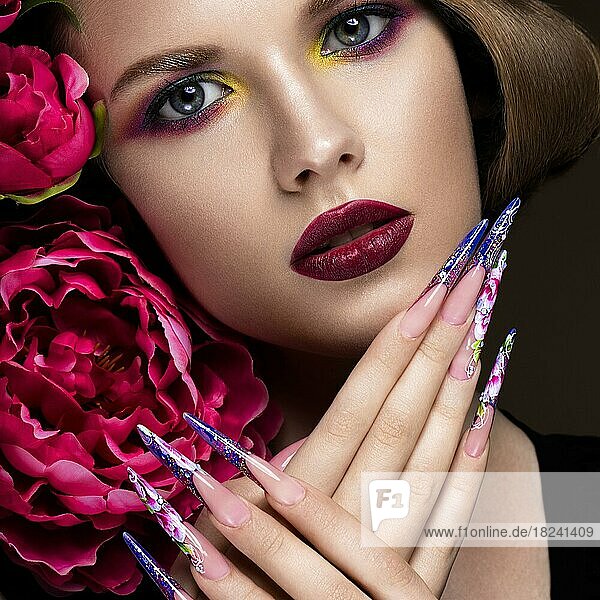 Beautiful girl with colorful make-up  flowers  retro hairstyle and long nails. Manicure design. The beauty of the face. Photos shot in studio