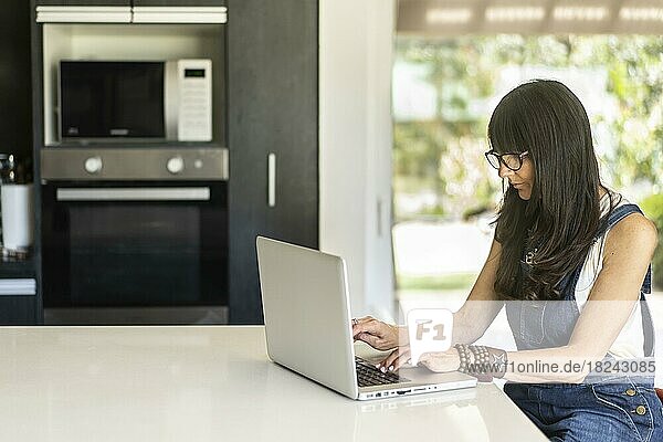 Geschäftsfrau  die von zu Hause aus arbeitet und auf einen Laptop schaut. Selbstbewusste Frau mit Laptop