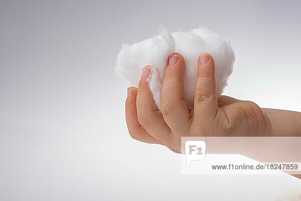 Hand hält etwas Baumwolle in der Hand auf einem weißen Hintergrund
