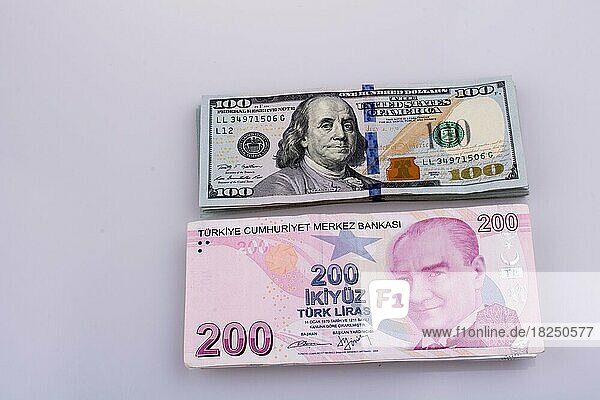 Amerikanische Dollar-Banknoten und Türkische Lira-Banknoten Seite an Seite auf weißem Hintergrund
