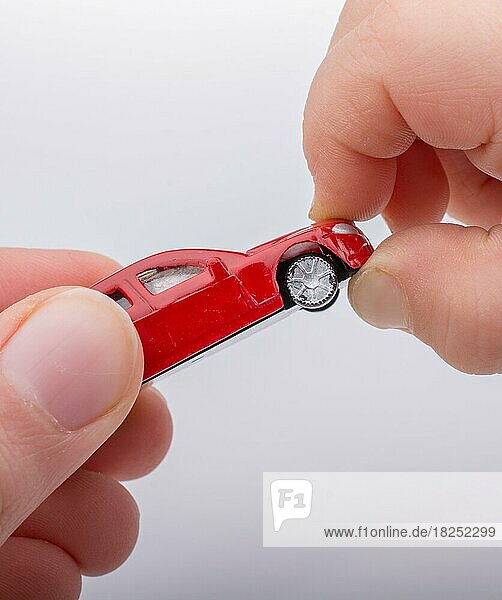 Kind verschenkt Spielzeugauto auf weißem Hintergrund