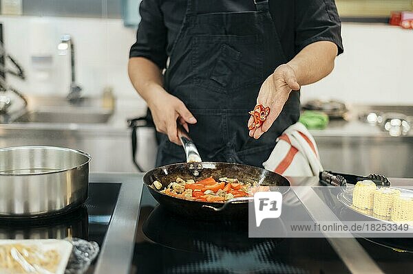 Männlicher Koch  der ein Chili-Gericht hinzufügt  Auflösung und hohe Qualität schönes Foto