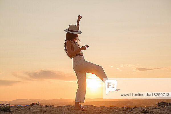 young girl on vacation dances in the sunset