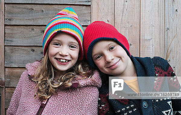 portrait of a brother and sister smiling together whilst outdoors