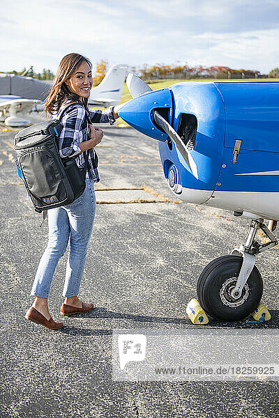 Young BIPOC Female Pilot doing preflight check on small plane
