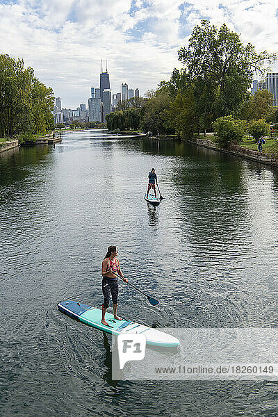 High angle view of male and female friend paddleboarding in river