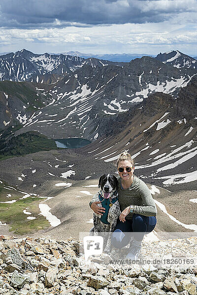 Portrait of happy woman embracing dog while hiking at Electric Pass