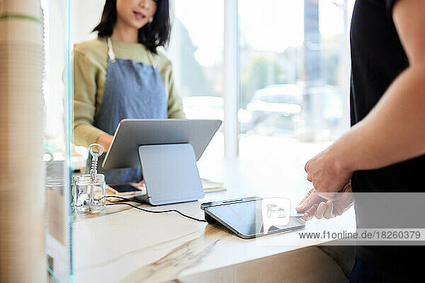 Mature male customer paying through credit card at checkout counter