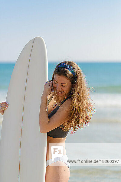 young woman with surfboard on the beach
