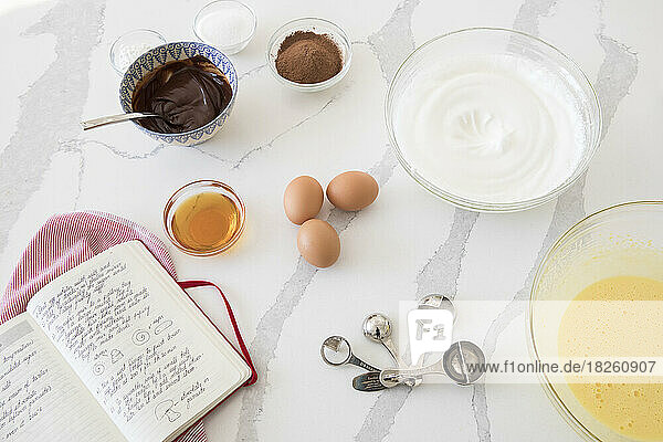 Baking Ingredients and recipe book on a white countertop