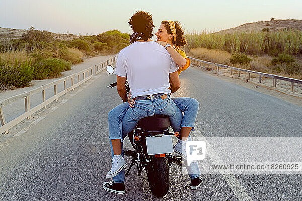 young couple travel happy by motorcycle on the road outdoors.