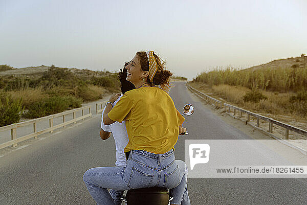 young couple on motorcycle on a road traveling to the beach
