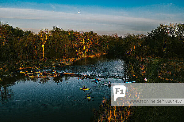 Kayaks on the river in front of forest and moon rise on adventure