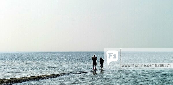 Zwei Personen auf einer Buhne an der Nordseeküste in Cuxhaven Sahlenburg  Landkreis Cuxhaven  Deutschland  Europa