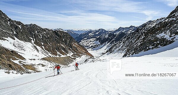 Two ski tourers walking on the rope on the glacier  ascent on Berglasferner  view into Berglastal  Stubai Alps  Tyrol  Austria  Europe