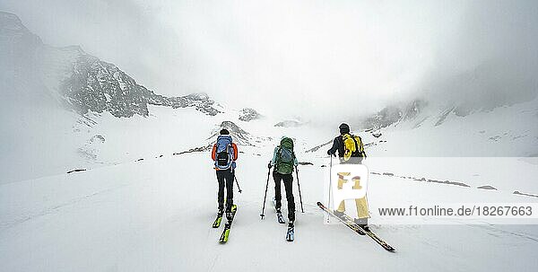 Drei Skitourengeher beim Aufstieg zum Sommerwandferner  wolkenverhangene Berge  Stubaier Alpen  Tirol  Österreich  Europa