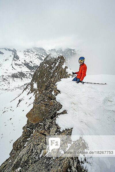 Skitourengeher am felsigen Grat mit Schnee  Obere Kräulscharte  Blick zur Inneren Sommerwand  Gletscher Sommerwandferner  wolkenverhangene Berge  Stubaier Alpen  Tirol  Österreich  Europa