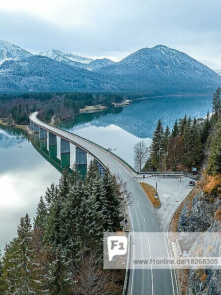 Straße mit Brücke am Wasser im Winter  Sylvensteinsee  Faller Klamm Brücke  Deutschland  Europa