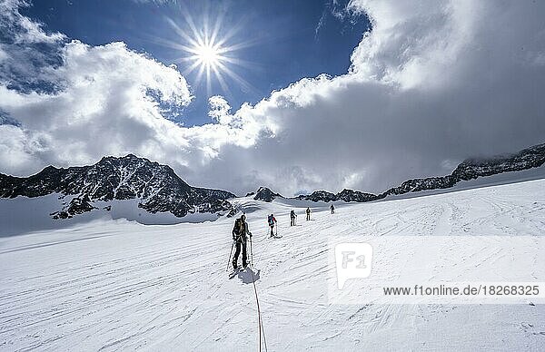 Group of ski tourers ascending on the rope  at Alpeiner Ferner  ascent to Obere Hölltalscharte  Sonnenstern  Stubai Alps  Tyrol  Austria  Europe