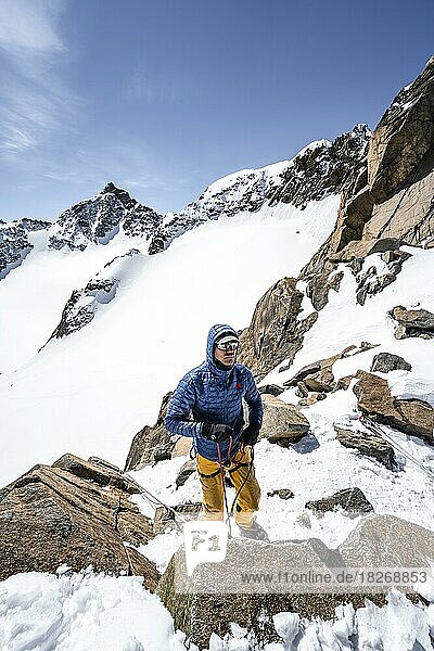 Skitourengeher bereitet Seilsicherung für Abstieg am Seil vor  Turmscharte  Ausblick auf den Gletscher Verborgen-Berg Ferner mit Gipfel Schrandele  Stubaier Alpen  Tirol  Österreich  Europa