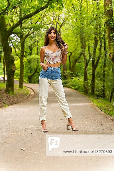 Portrait of a Caucasian girl on a path in a city park  fashionably posed in nature