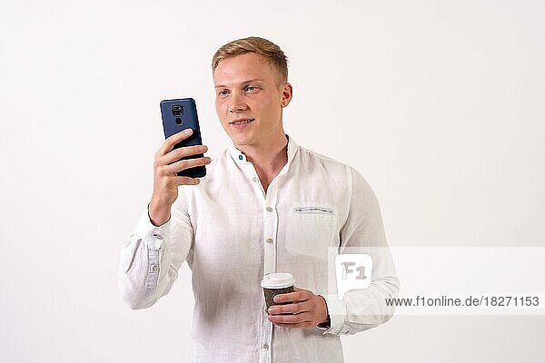 Blonde kaukasischen Geschäftsmann Mann lächelnd mit einem Telefon auf einem weißen Hintergrund