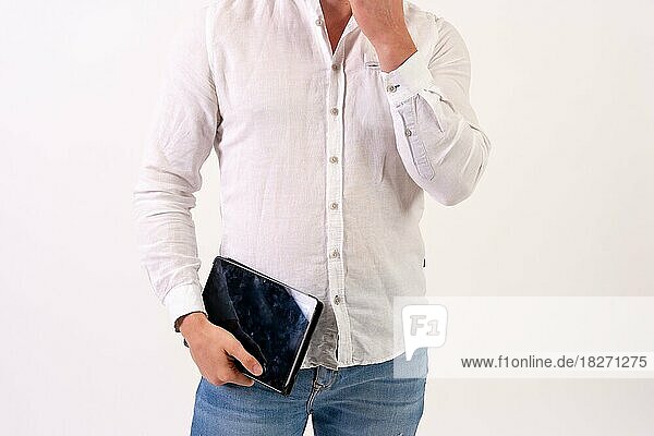 Ein kaukasischer Geschäftsmann in einem weißen Hemd arbeitet mit einem Tablet auf einem weißen Hintergrund