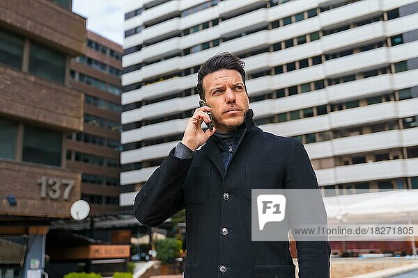 Middle-aged Caucasian businessman talking on the phone in the city