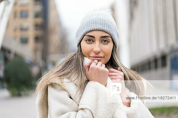 Winterporträt einer kaukasischen Frau mit einer Wollmütze in der Stadt  sehr kalt