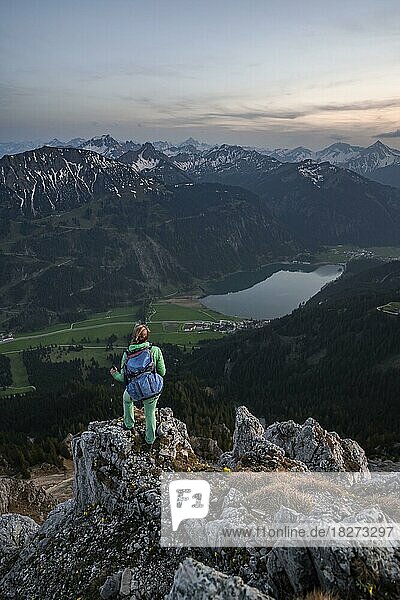 Evening atmosphere  mountaineer at the summit of Schartschrofen looking down on Haldensee  Tannheimer Bergen  Allgäu Alps  Tyrol  Austria  Europe
