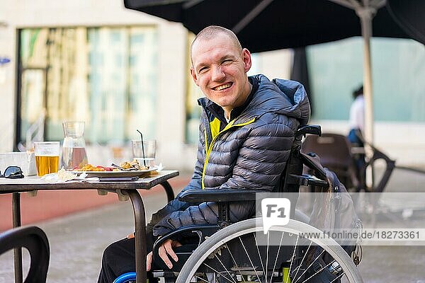 Portrait of a disabled person in a wheelchair in a restaurant  normality of disabled people