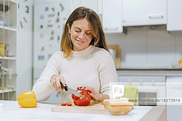Vegetarische Frau beim Zubereiten eines Gemüsesandwichs in der Küche zu Hause