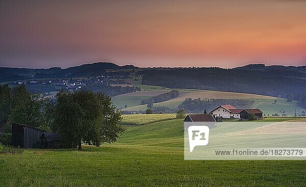 Ein Bauernhof bei Sonnenuntergang  ein Dorf im Hintergrund  typisch bayerische Landschaft  Oberpfalz  Bayern  Deutschland  Europa