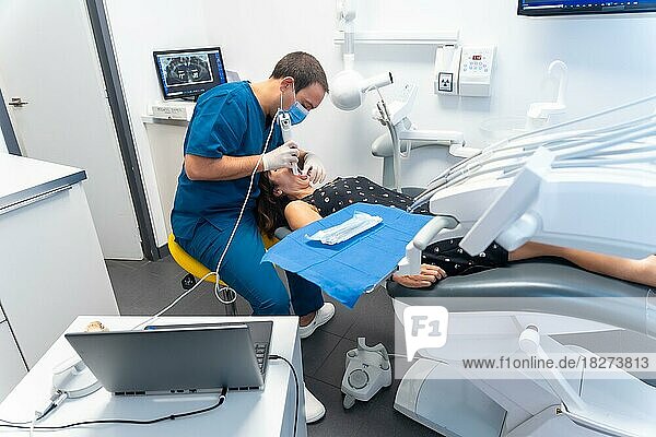 Zahnklinik  Zahnarzt bei der Durchführung eines 3D-Scans an einem Patienten  der in einem modernen Operationssaal liegt