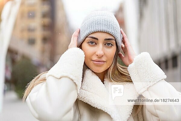 Winter portrait of a caucasian woman in a wool hat in the city  lifestyle