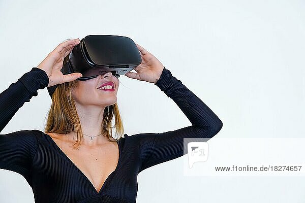 Woman wearing virtual reality goggles on white background  futuristic concept  metaverse  smiling