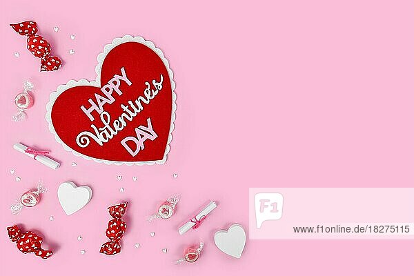Valentine's Day flat lay mit Herz mit Text Happy Valentine's Day  Süßigkeiten und Herz Ornamente auf rosa Hintergrund mit Kopie Raum