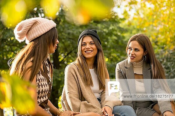 Women friends in a park in autumn carefree  fashionable autumn lifestyle with positive energy