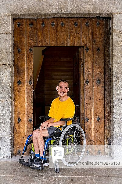 Eine behinderte Person in einem Rollstuhl neben einer Holztür