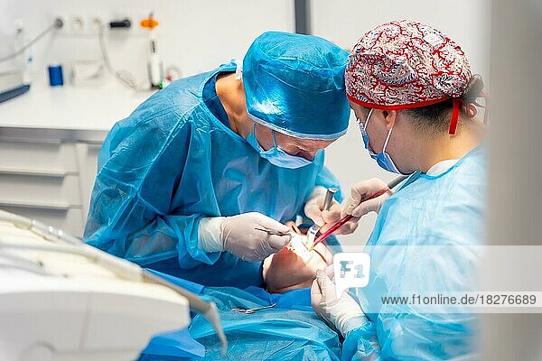 Zahnklinik  Zahnarzt und Assistentin führen eine orale Operation an einem Kunden durch