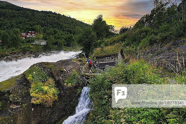 Hikers at Hellesyltfossen waterfall  evening sky  Hellesylt  Møre og Romsdal  Norway  Europe