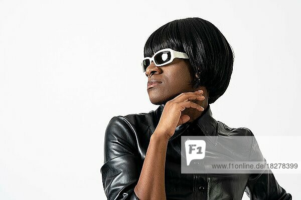 Black ethnic man in studio with white background  LGTBI concept  wearing leather and looking to the left