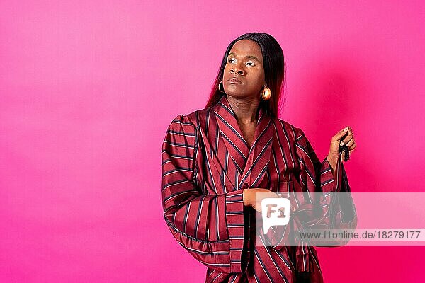 Schwarzer ethnischer Mann in einem Studio  LGTBI Konzept  trägt einen roten Kimono und eine lange Perücke
