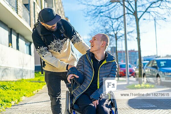 Eine behinderte Person im Rollstuhl mit einem lächelnden Freund  behinderte Normalität