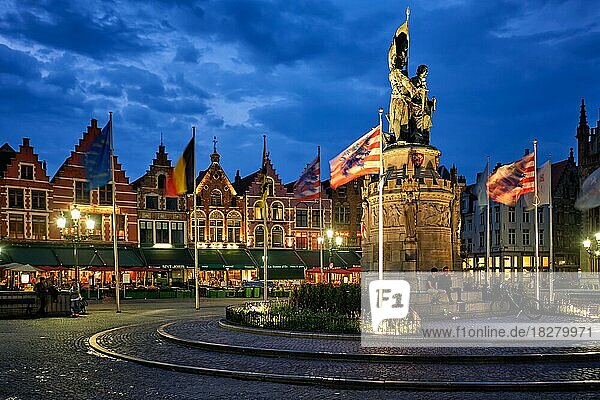 Brügge Grote Markt berühmter Touristenplatz mit vielen Cafés und Restaurants und Jan Breydel und Pieter de Coninck Monument am Abend  Brügge  Belgien  Europa