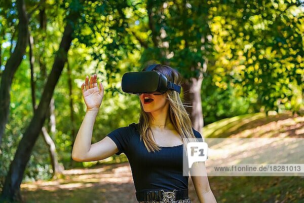 Frau mit Virtual-Reality-Brille genießt die Natur und sieht Dinge durch die Brille