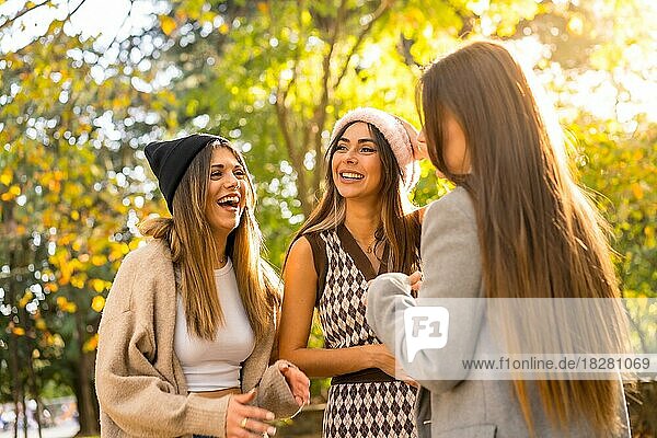 Women friends smiling in a park in autumn with woolen hats  trendy autumn lifestyle