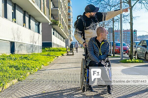 Eine behinderte Person im Rollstuhl geht mit einem Freund im Rollstuhl auf der Straße spazieren
